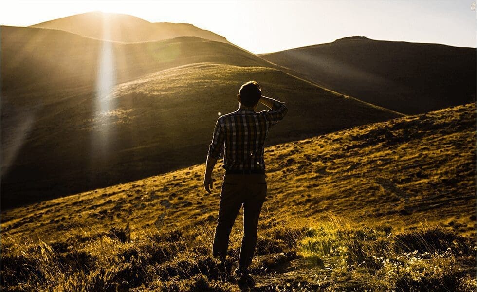Man stanind on a hilltop in Quchan, Iran searching the horizon